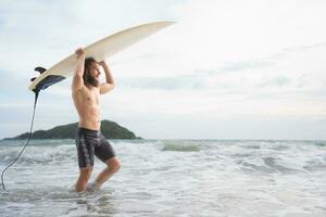 surfer uomo con il suo tavola da surf su il spiaggia. foto