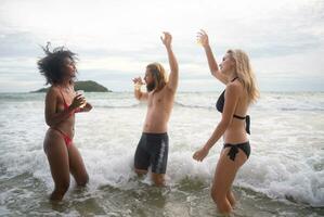 gruppo di amici avendo divertimento su il spiaggia. giovane donne avendo divertimento su il spiaggia. foto