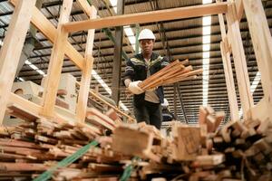 un' falegname lavori nel un' di legno fabbrica, raccogliere legna quello ha passato attraverso il legna fresa in piccolo pezzi. per essere inviato per essere formato in di legno pallet foto