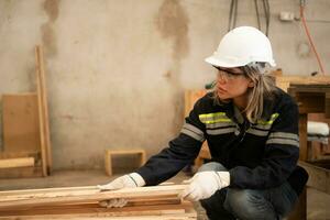 un' falegname lavori nel un' carpenteria officina. lei raccoglie il legna quello passa attraverso il legna angolo macinino. foto