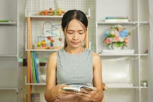 donna lettura un' libro nel il biblioteca foto