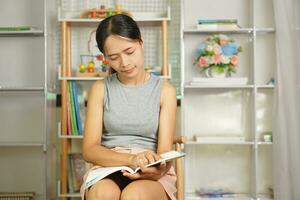 donna lettura un' libro nel il biblioteca foto