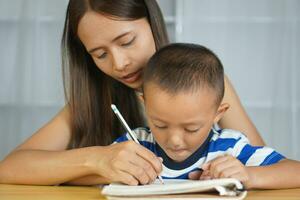 madre detiene mani con figlio per pratica scrittura lettere foto