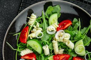 pasta insalata fusilli pasta, cetriolo, pomodoro, verde lattuga, cipolla delizioso salutare mangiare cucinando aperitivo pasto cibo merenda su il tavolo copia spazio cibo sfondo foto