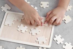 ragazzino asiatico che gioca a puzzle in legno foto