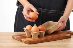donna che tiene le uova di gallina fresche in una scatola di cartone