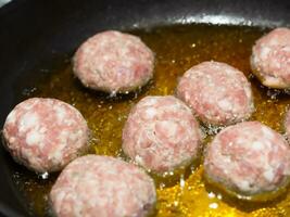 Polpette con olio nel frittura padella. foto