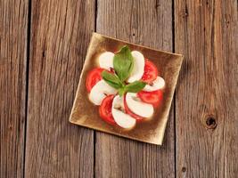 insalata caprese - fette di pomodoro fresco e mozzarella foto