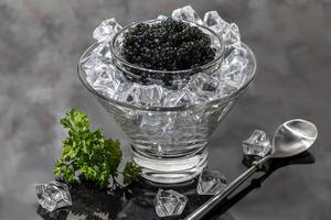 caviale nero in un piatto su uno sfondo chiaro. concetto di cibo sano. foto