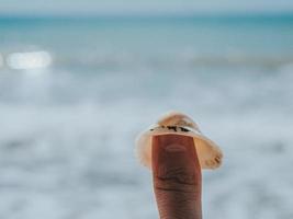 primo piano di una conchiglia su un grosso dito maschio su uno sfondo sfocato foto