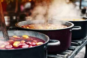 bevande frutta e frutti di bosco caldo vin brulé vino nel pentole con vapore nel strada cibo mercato. generativo ai foto