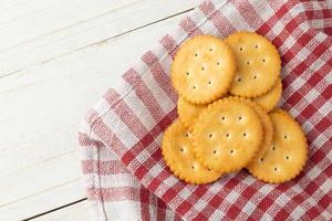 biscotti cracker con tovaglia su sfondo tavolo in legno bianco foto