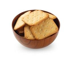 biscotti cracker in ciotola di legno isolato su sfondo bianco foto