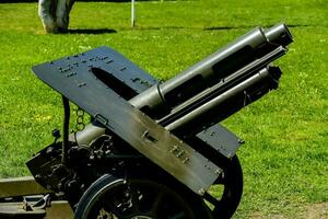 un' grande cannone seduta su superiore di un' verde campo foto