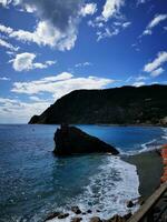 foto di un' pittoresco spiaggia con un' prominente roccia formazione nel il cristallo chiaro acqua