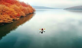 aereo Visualizza di un' persona canottaggio su un' calma lago nel autunno. ai generato foto