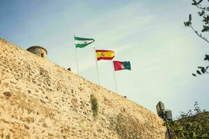 il bandiera di Spagna e il bandiere di il regioni di Spagna installato su il fortezza foto