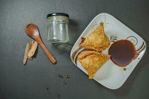 samosa, indiano vegetariano spuntini servito con tamarindo mostarde foto