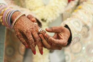 indiano sposo e sposa mano nel mano mostrando squillare foto