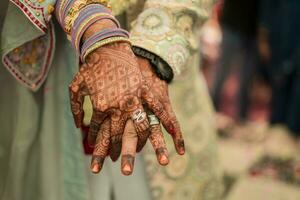 indiano sposo e sposa mano nel mano mostrando squillare foto