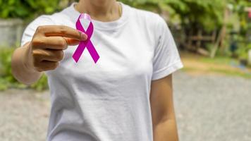 nastro rosa sulla mano femminile, concetto di assistenza sanitaria e simbolo del cancro al seno.