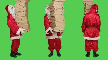 santo nick Tenere Pizza scatole, consegna enorme mucchio di veloce cibo al di sopra di pieno corpo schermo verde. Santa Claus incarnazione indossare tradizionale dicembre costume con bianca barba, scatola di cartone pacchi. foto