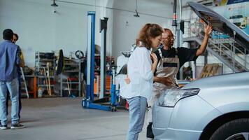 certificato tecnico nel box auto spazio di lavoro fissaggio auto per cliente, accuratamente controllo sotto veicolo cappuccio. specialista fare annuale Manutenzione su cliente automobile nel auto riparazione negozio foto