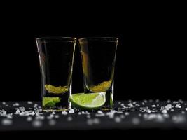 due colpi di tequila oro con lime succoso e sale marino foto