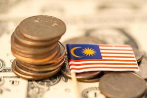 Bandiera della Malesia su sfondo di monete, concetto di affari e finanza. foto