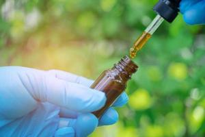 medici che tengono una bottiglia di prodotto vegetale a base di olio di erbe, dosaggio di goccioline foto