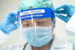 medico asiatico che indossa una tuta in dpi per proteggere il coronavirus foto