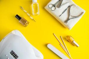 set di strumenti per manicure e cura delle unghie su uno sfondo giallo foto
