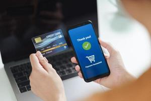 donna che tiene la carta di credito e usa lo smartphone per lo shopping online foto