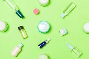 gruppo di plastica cura del corpo bottiglia piatto posare composizione con cosmetico prodotti su verde sfondo vuoto spazio per voi design. impostato di bianca cosmetico contenitori, superiore Visualizza con copia spazio foto