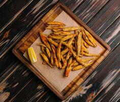 di legno tavola di fritte bianchetti con fette di Limone foto