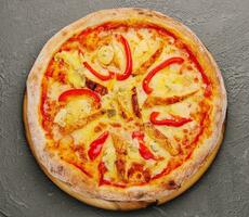 un' superiore Visualizza di formaggio pollo Pizza con affettato rosso campana Pepe foto