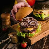 vicino su Visualizza di femmina cucinando fresco gustoso hamburger foto