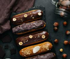 dolce cioccolato eclairs su nero di legno tavola foto