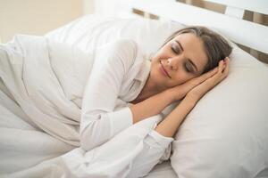 bella giovane donna che dorme nel letto foto