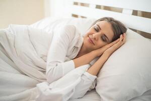 bella giovane donna che dorme nel letto foto