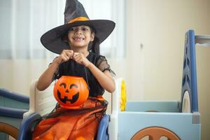 contento asiatico bambino ragazza nel un' strega costume per Halloween. trucco o trattare. bambini trucco o trattare. foto