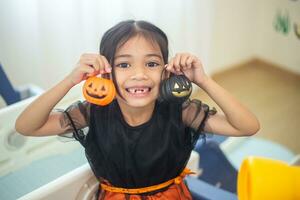 contento asiatico bambino ragazza nel un' strega costume per Halloween. trucco o trattare. bambini trucco o trattare. foto