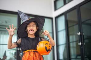 contento asiatico bambino ragazza nel un' strega costume per Halloween. trucco o trattare. bambini trucco o trattare. foto