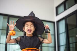 contento asiatico bambino ragazza nel un' strega costume per Halloween. trucco o trattare. bambini trucco o trattare. foto