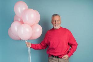 uomo felice che celebra tenendo palloncini rosa foto