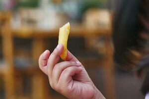 bambino mangiare francese patatine fritte vicino su foto