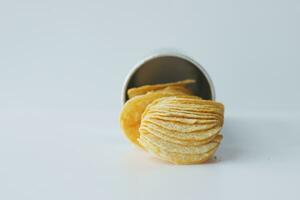 le patatine che si rovesciano formano un pacchetto sul tavolo foto