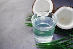 fetta di cocco fresco e bicchiere di acqua di cocco sul tavolo foto