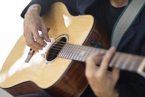 mano del primo piano che suona il tempo della musica della chitarra foto