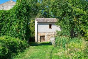 vecchia casa di mattoni bianchi nel bosco foto